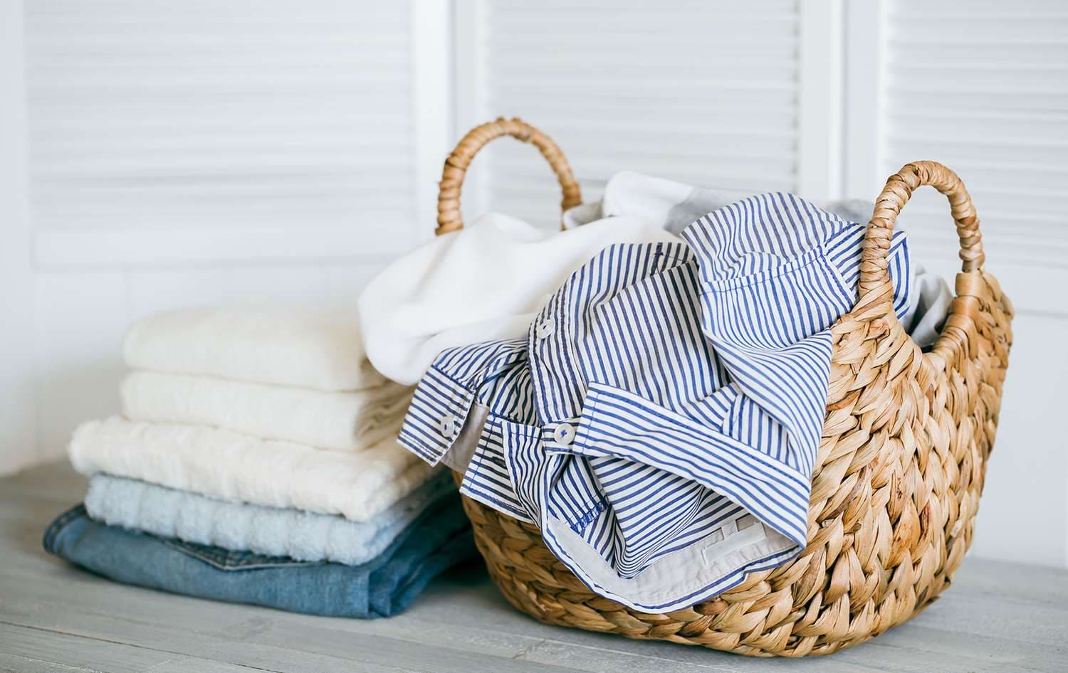 Folded laundry in a basket on top of a rented washing machine